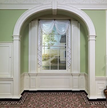 An arched niche interrupting the cornice in the Benkard Room in the American Wing of The Met.