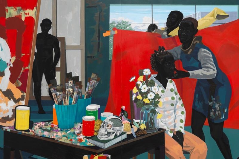 A woman sits in a chair in a painting studio as another woman grips her head and another raises a red cloth behind her