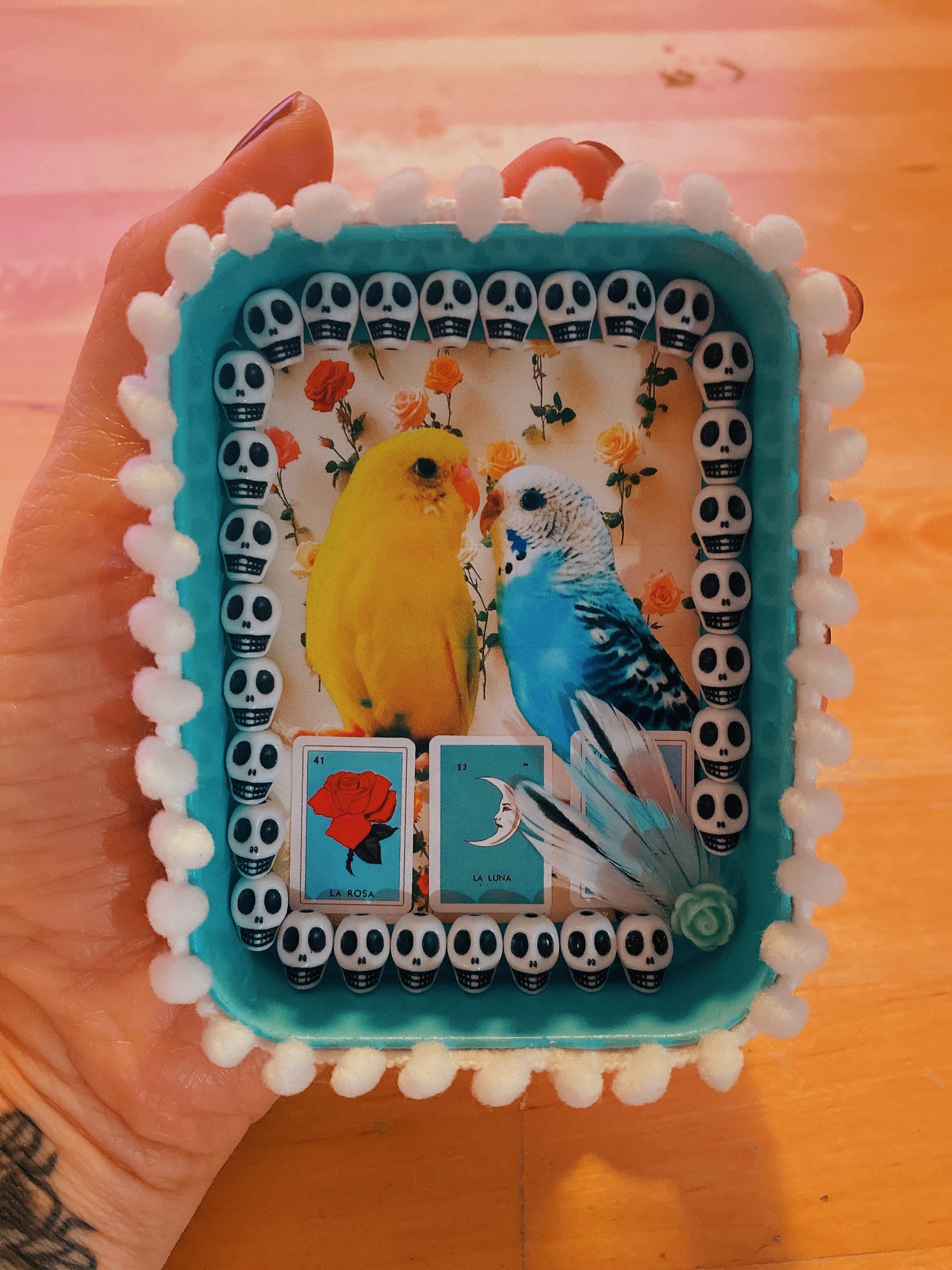 A mixed media diorama with symbols of love and death